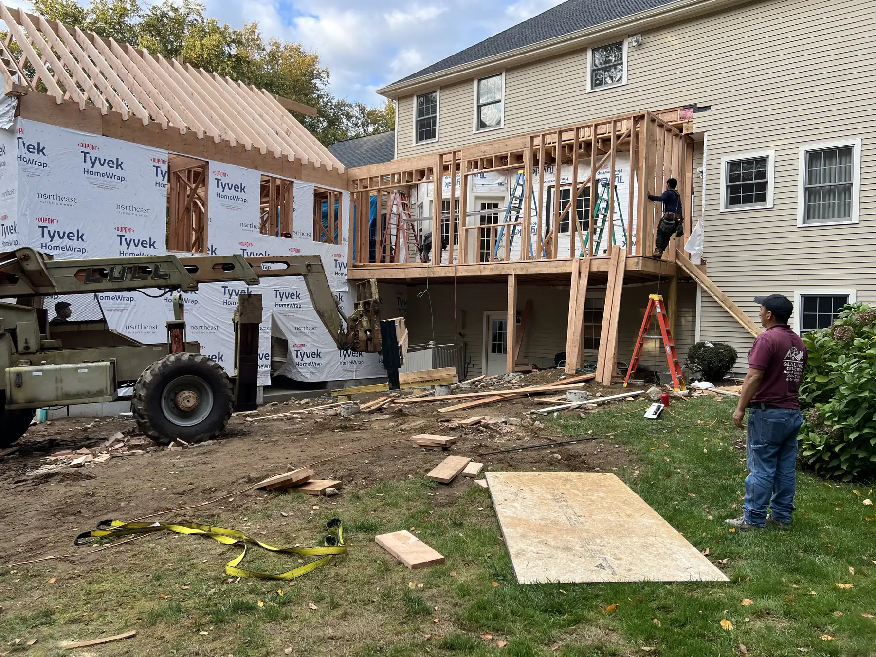 Rear addition and deck framed onto an existing house with a lift on site
