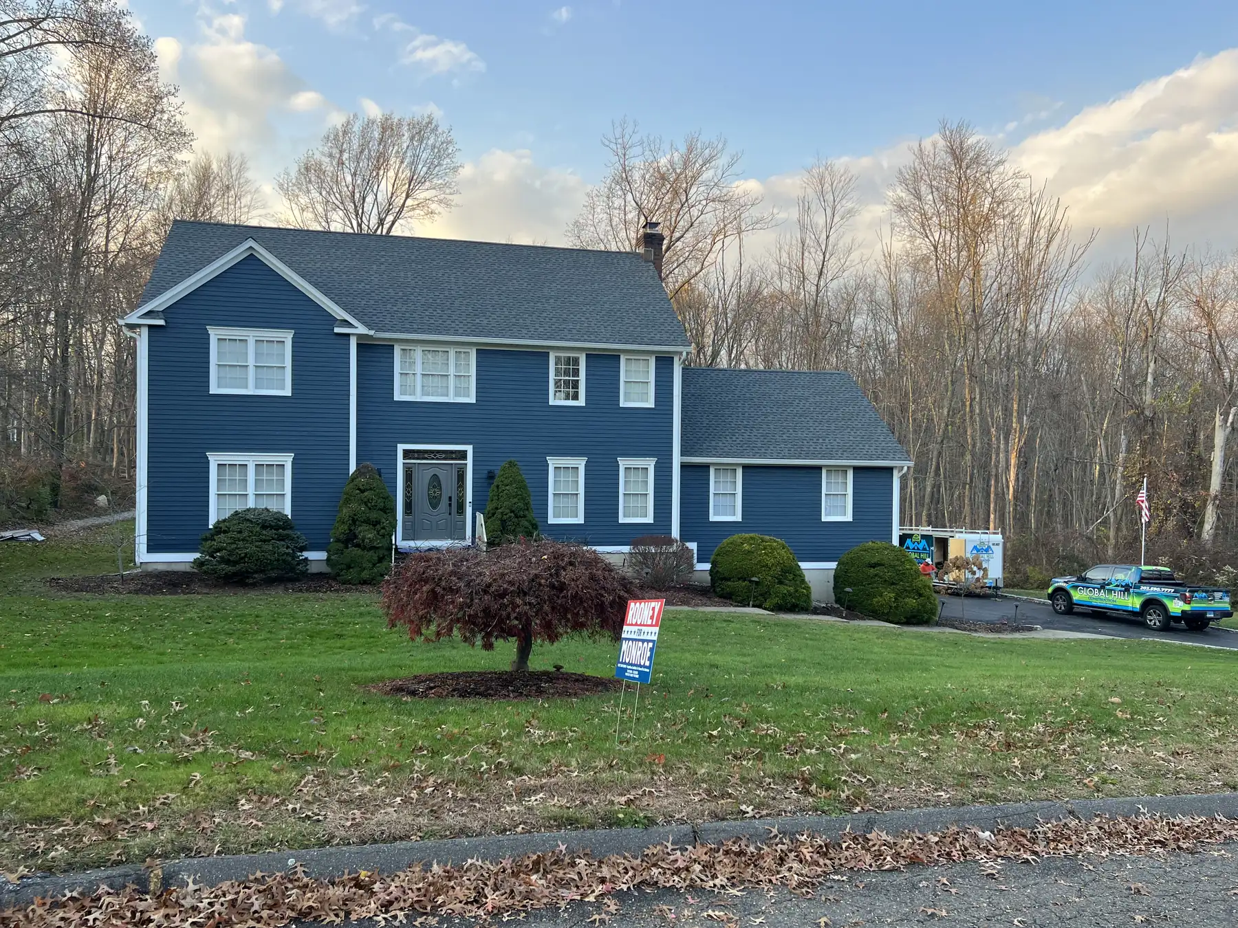 Blue clapboard colonial with white trim, a red maple in the front lawn and a new front entry