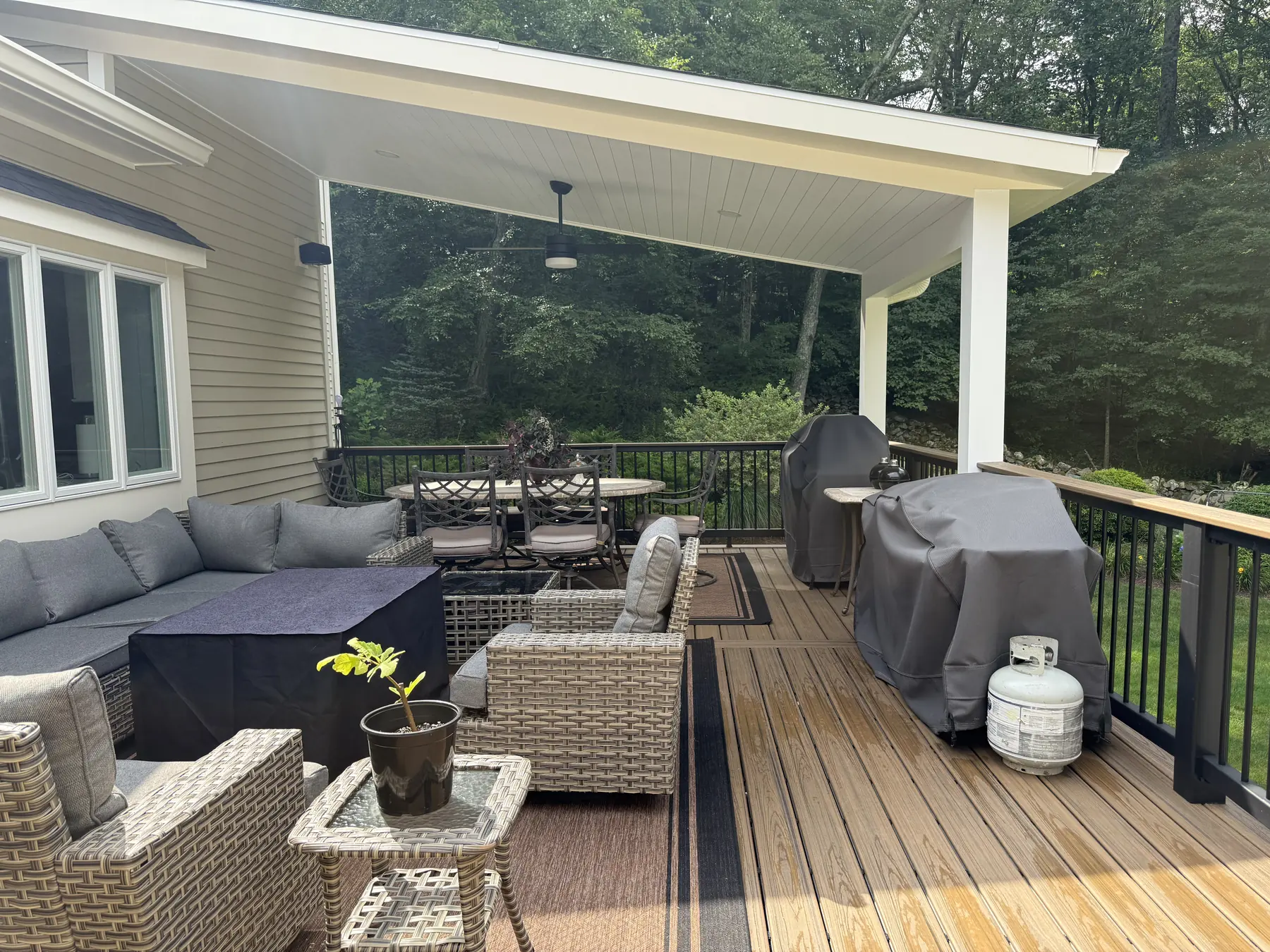 Covered deck with a timber ceiling, outdoor seating and black railings