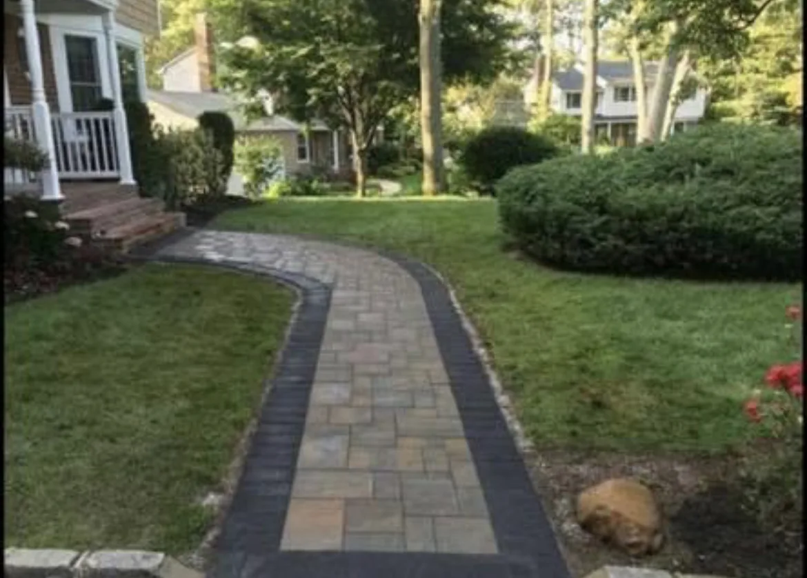 Paver walkway curving across a lawn to a front entry