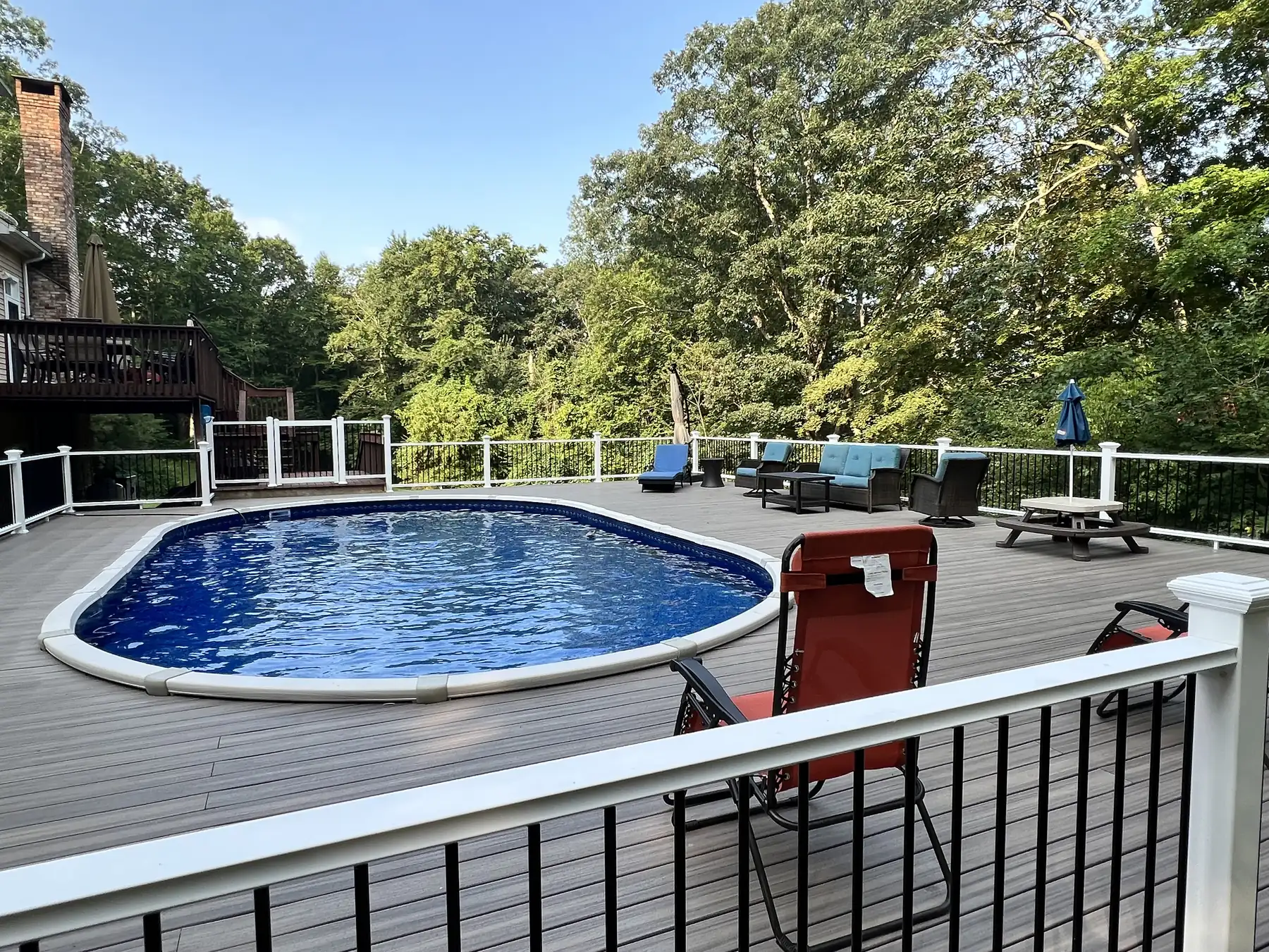 Composite pool deck with railings around an above ground pool
