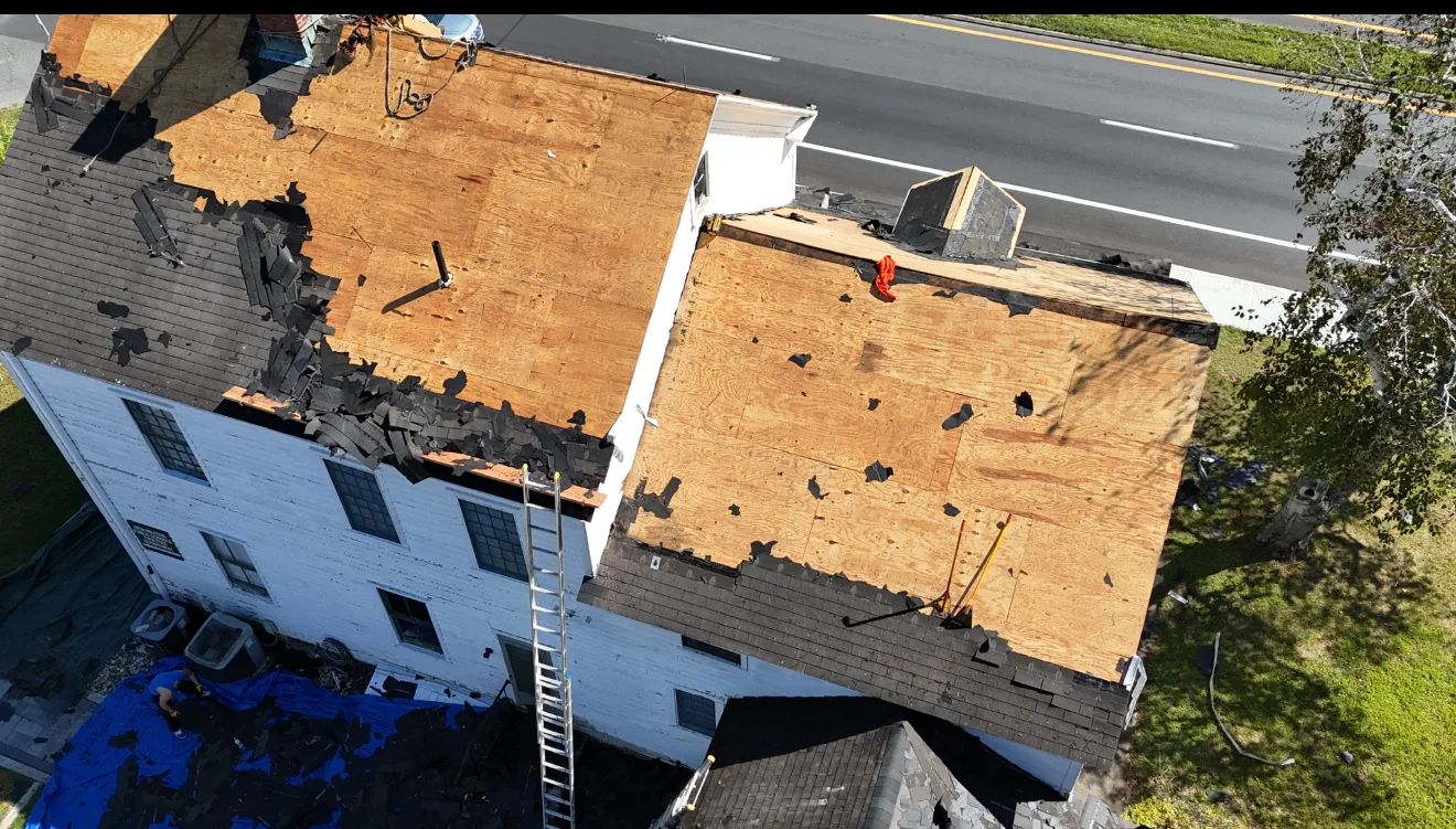 Aerial view of a roof torn off to the bare deck partway through a replacement