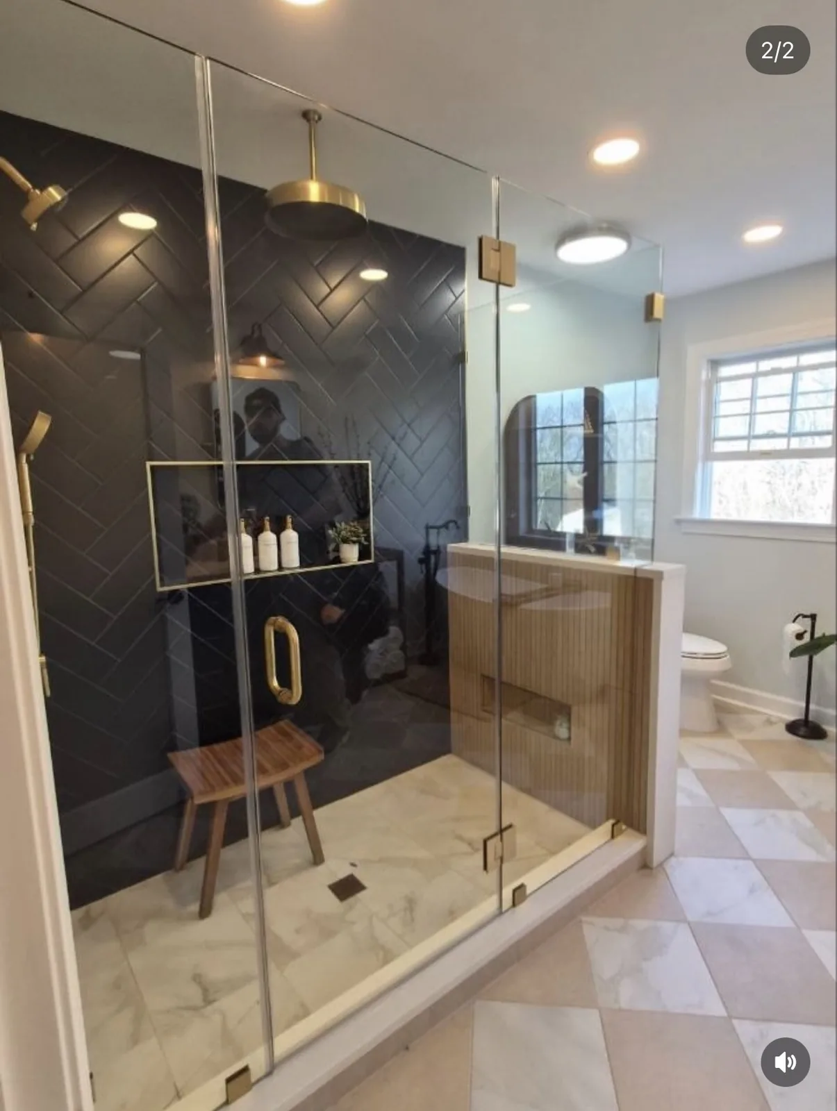 Shower room with navy herringbone tile, brass fittings and a timber bench
